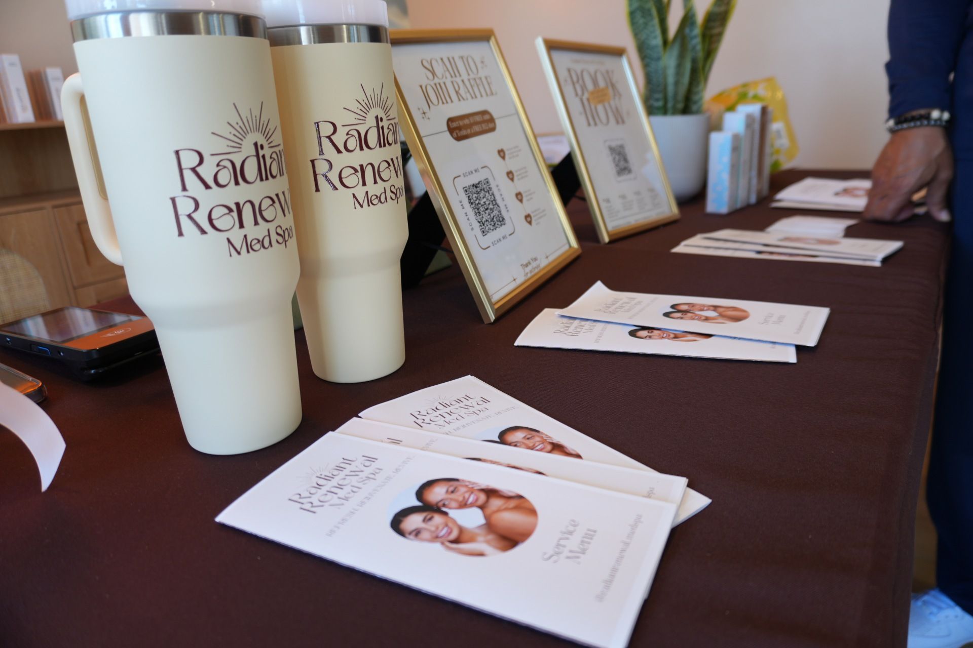 A table with a couple of mugs and pamphlets on it