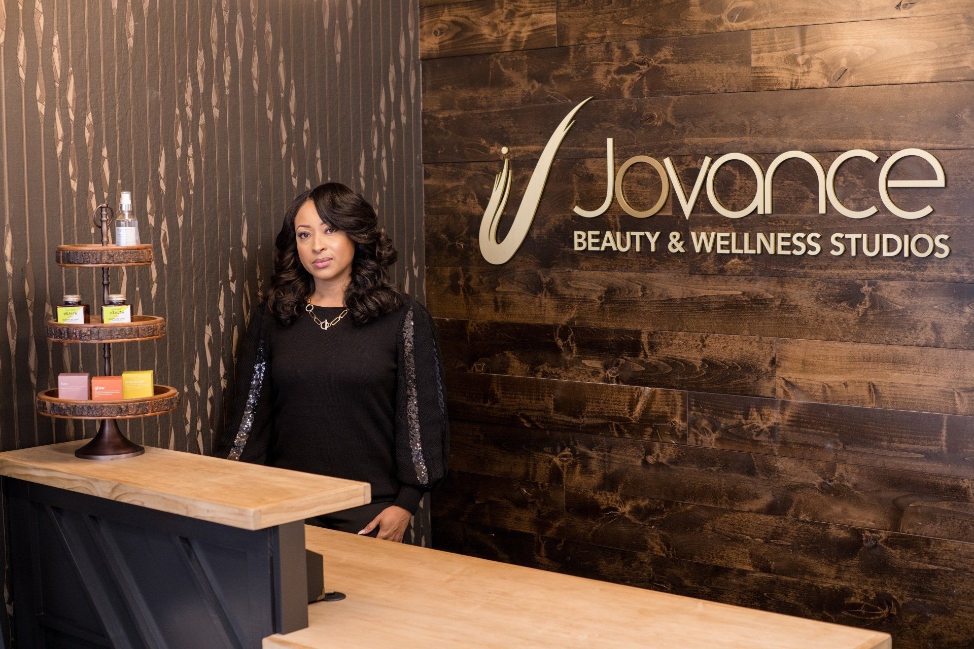 A woman is standing at a counter in a beauty and wellness studio.