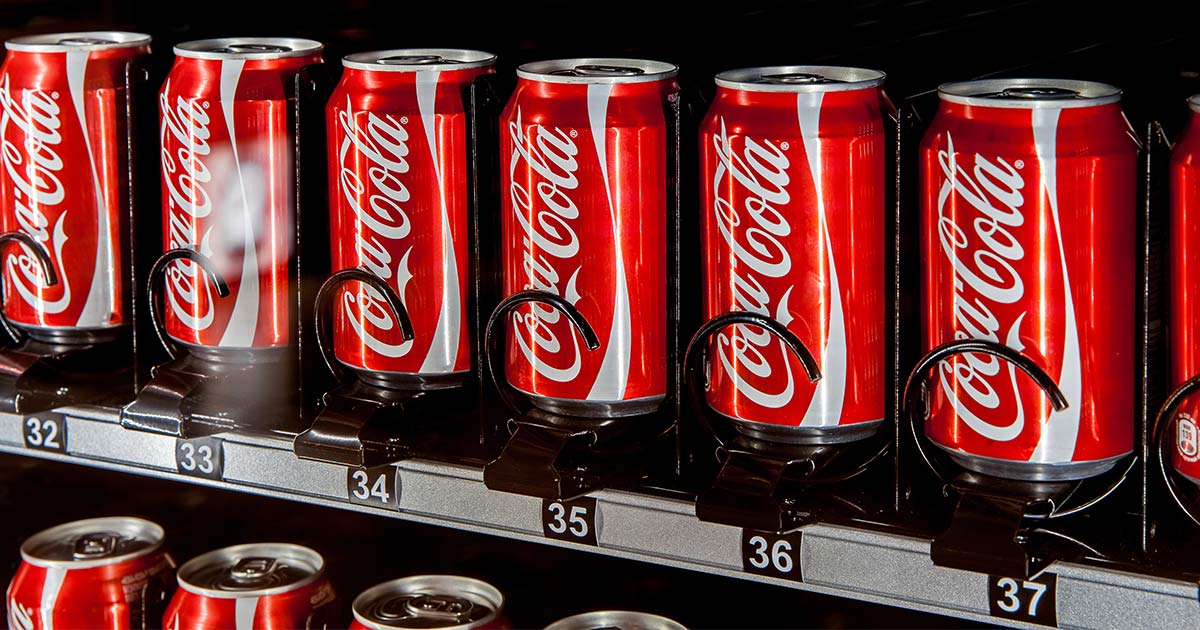 lattine di Coca-Cola in un distributore automatico