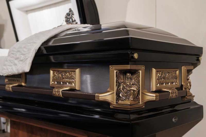 a coffin is decorated with white roses and green carnations