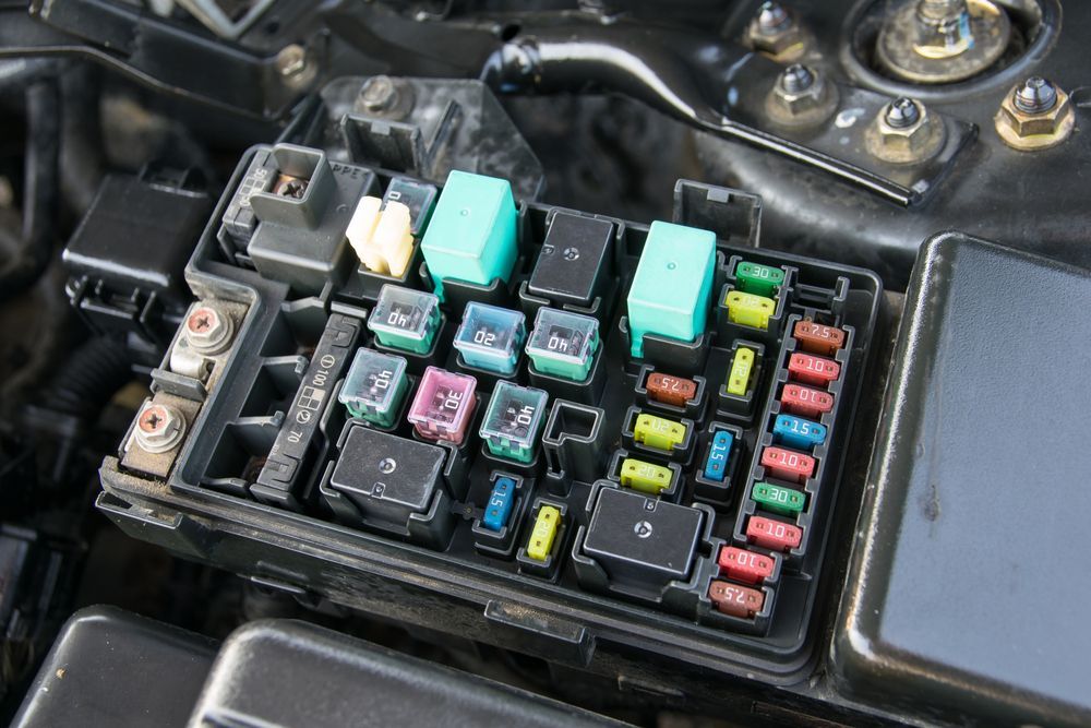 A fuse box is sitting under the hood of a car - Sean's Auto Care