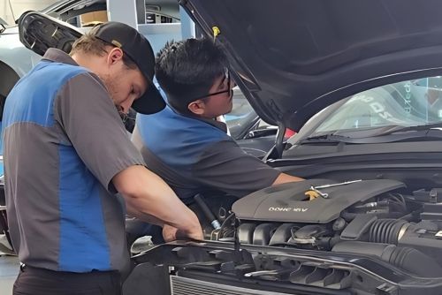 Two men are working on the engine of a car - Sean's Auto Care