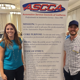 Two people standing in front of a sign | Sean's Auto Care