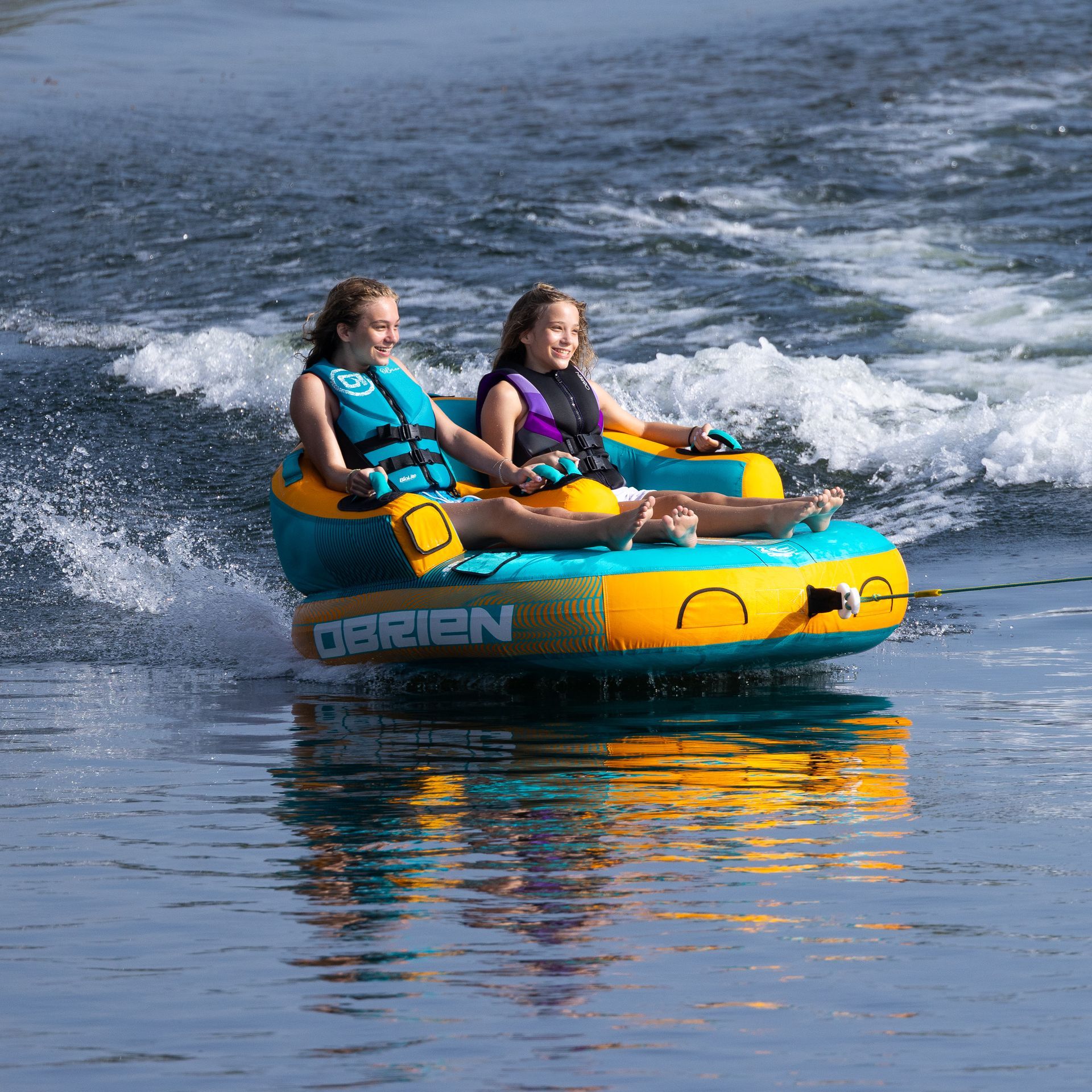 A man and a woman are riding a tube in the water.