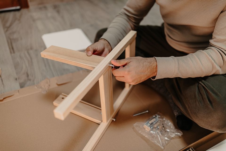 man assembles wooden furniture