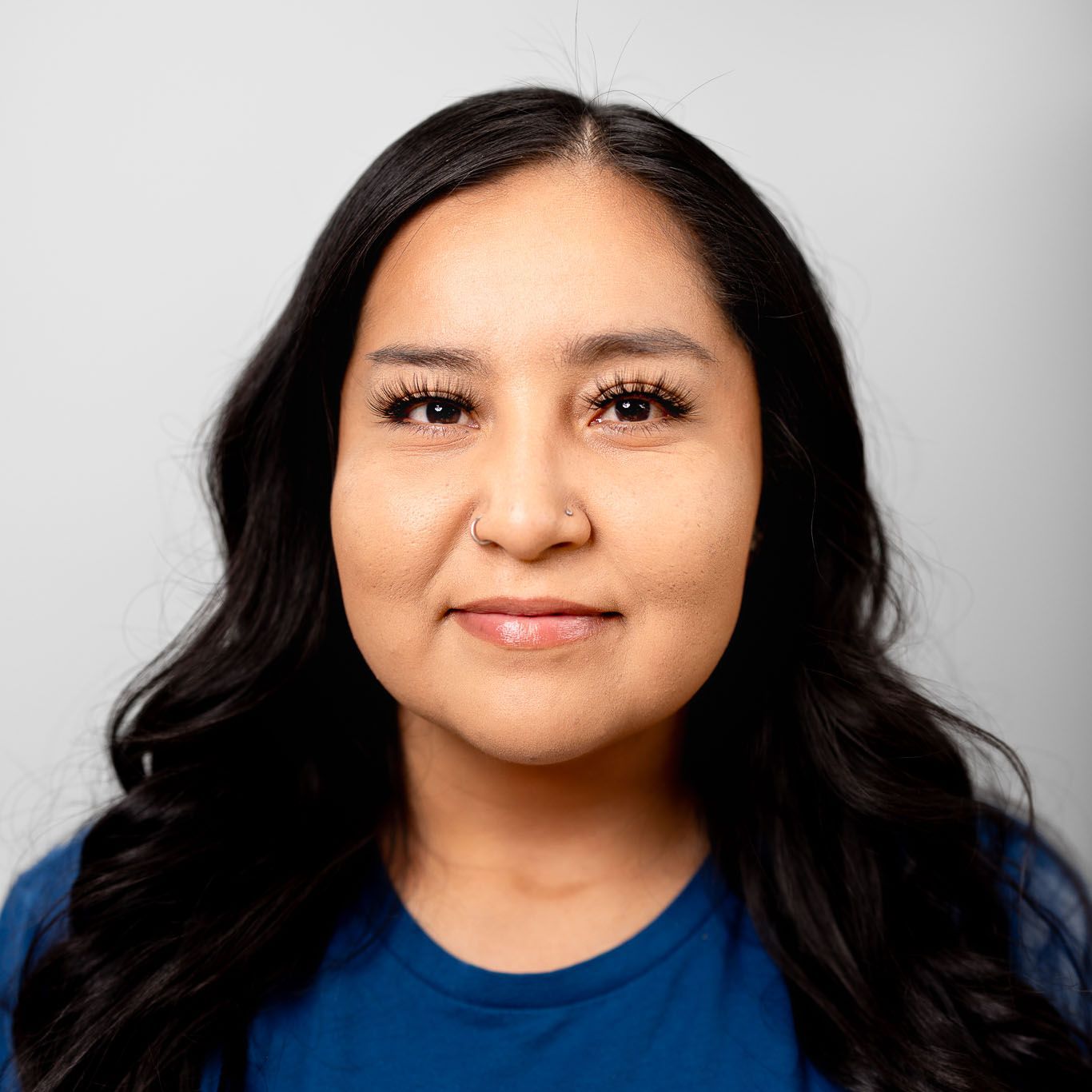 The woman is wearing a blue shirt and smiling for the camera.