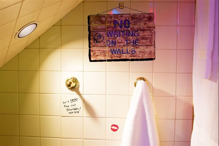 A bathroom with a sign that says no waiting on the walls