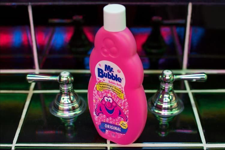 A pink bottle of mrs. bubble sits on a tiled counter