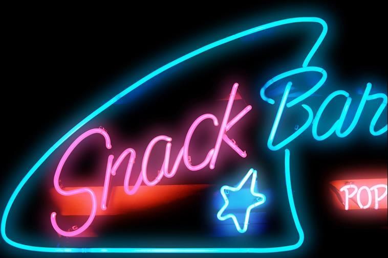 A neon sign that says snack bar on it