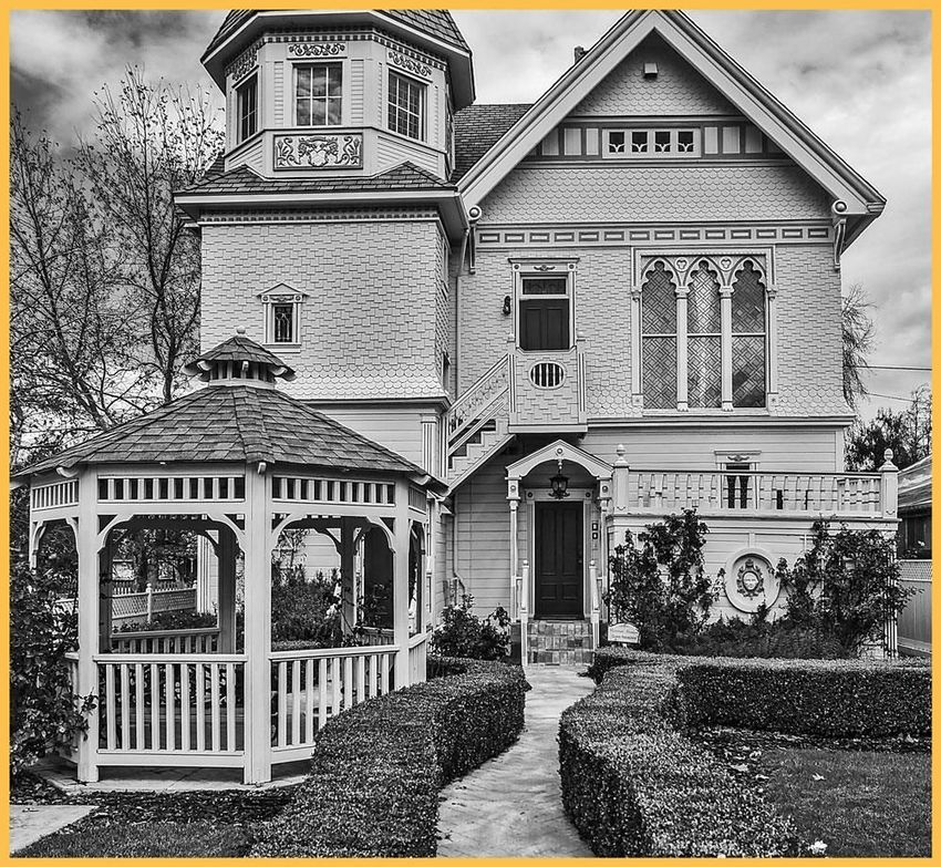 A black and white photo of a house with a gazebo in front of it