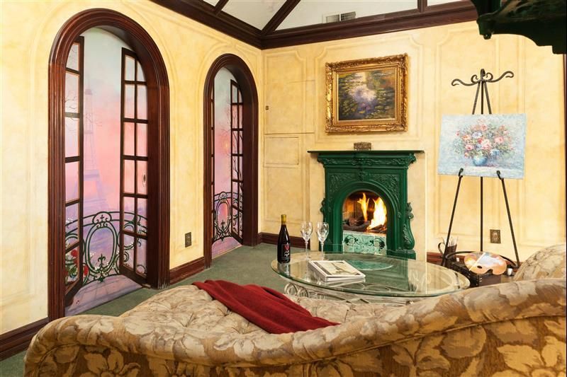 A living room with a fireplace and a painting on the wall