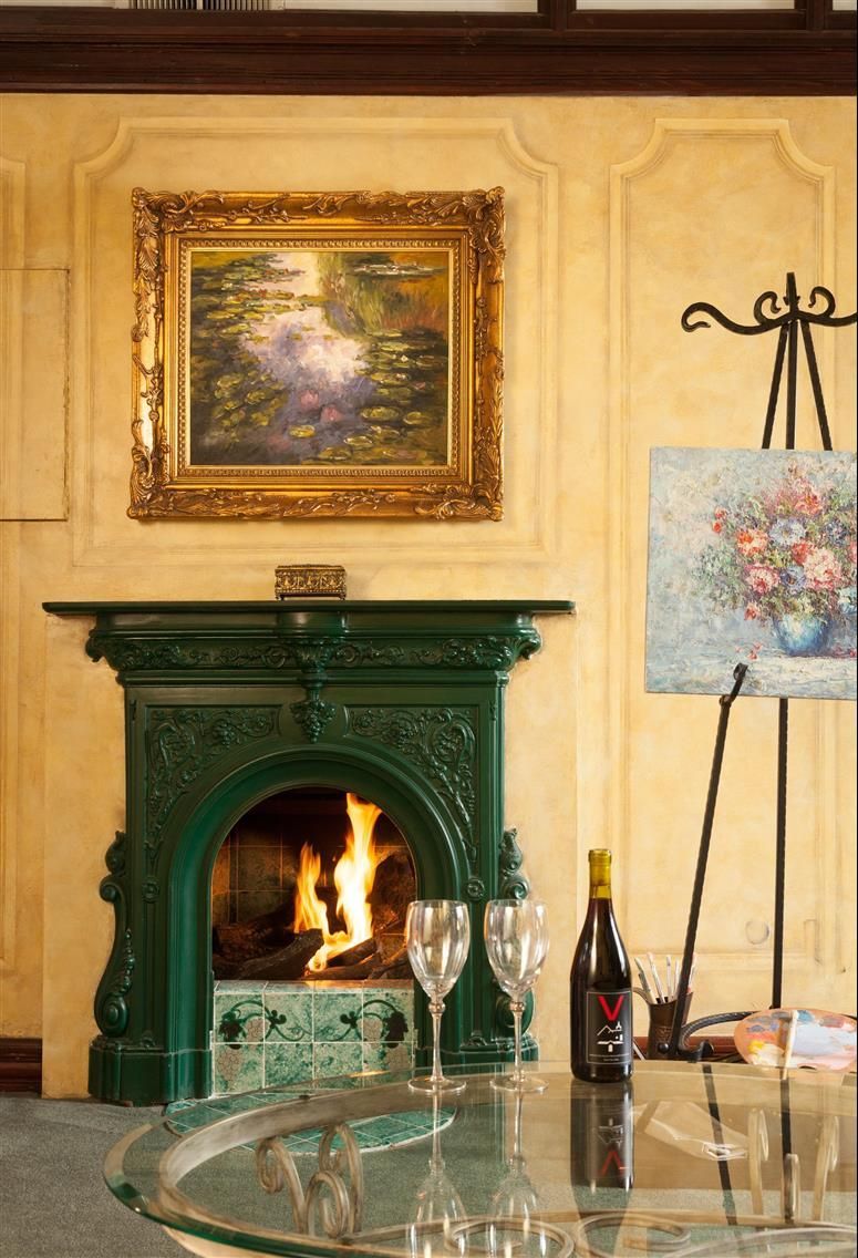 A living room with a fireplace and a painting on the wall.