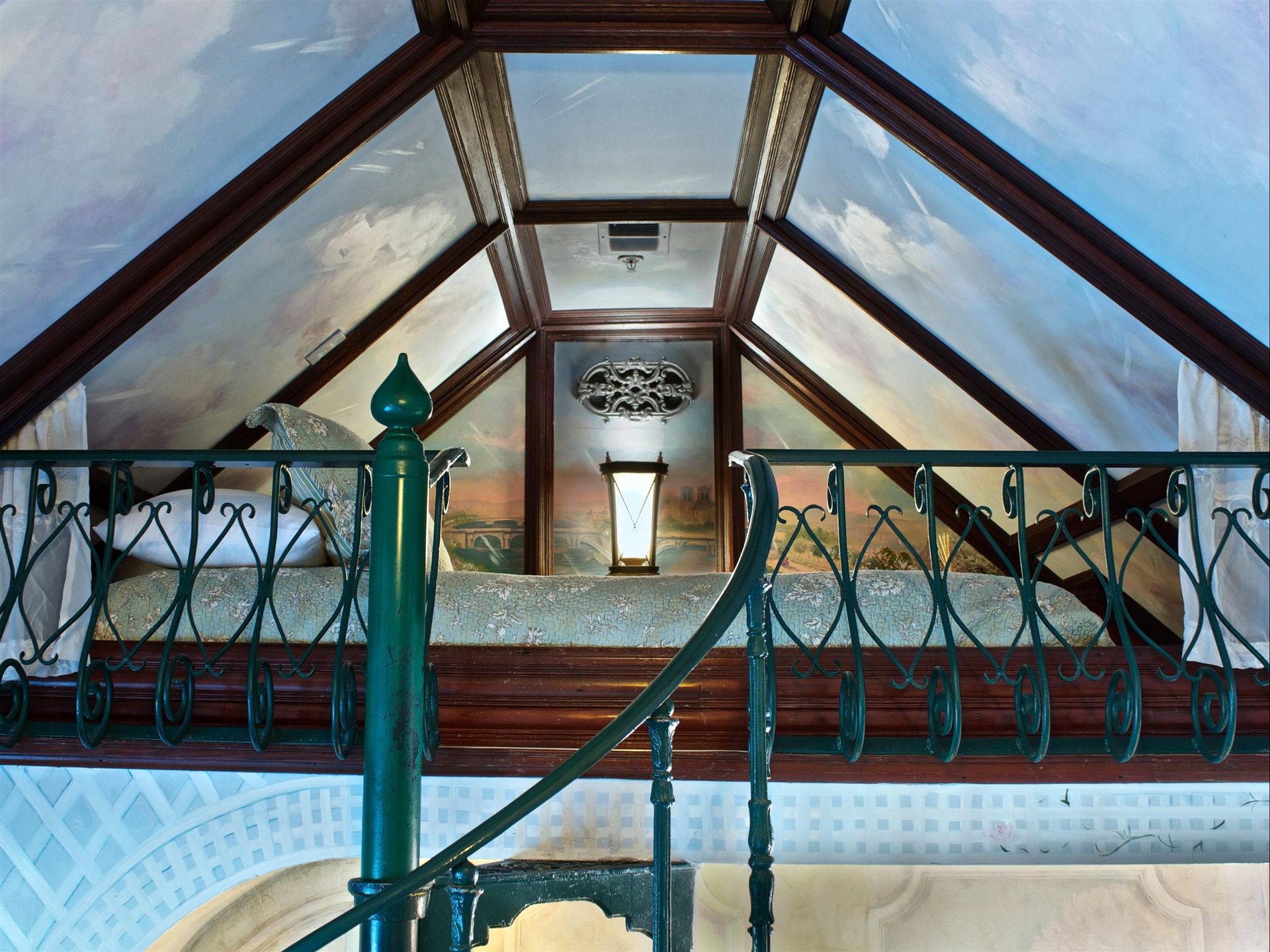 A staircase leading up to a bedroom with a painting on the ceiling