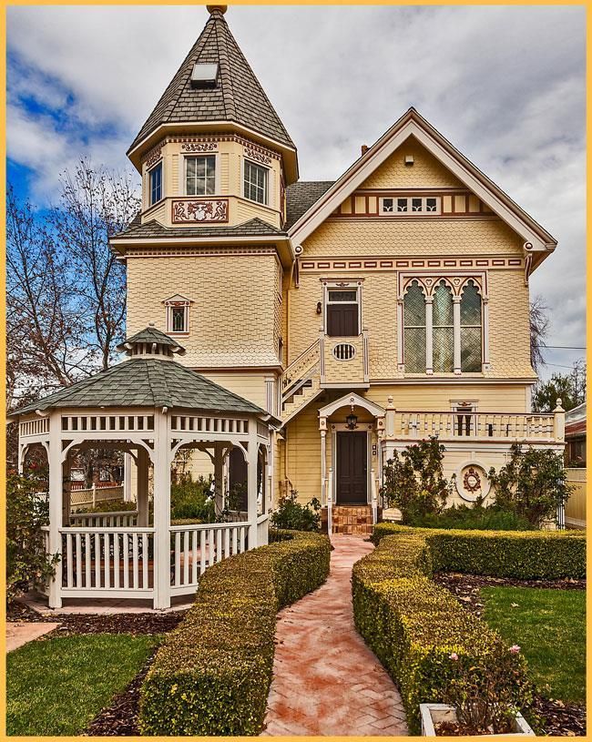 A large yellow house with a gazebo in front of it