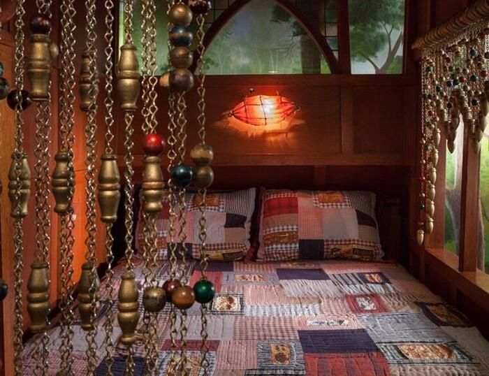 A bedroom with a bed and chains hanging from the ceiling