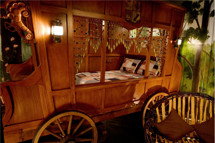 A wooden wagon with a bed inside of it