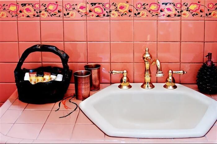 A bathroom with pink tiles and a white sink