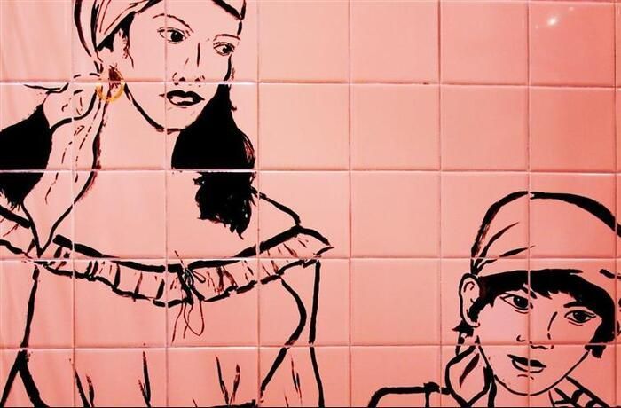 A drawing of a woman and a boy on a pink tile wall