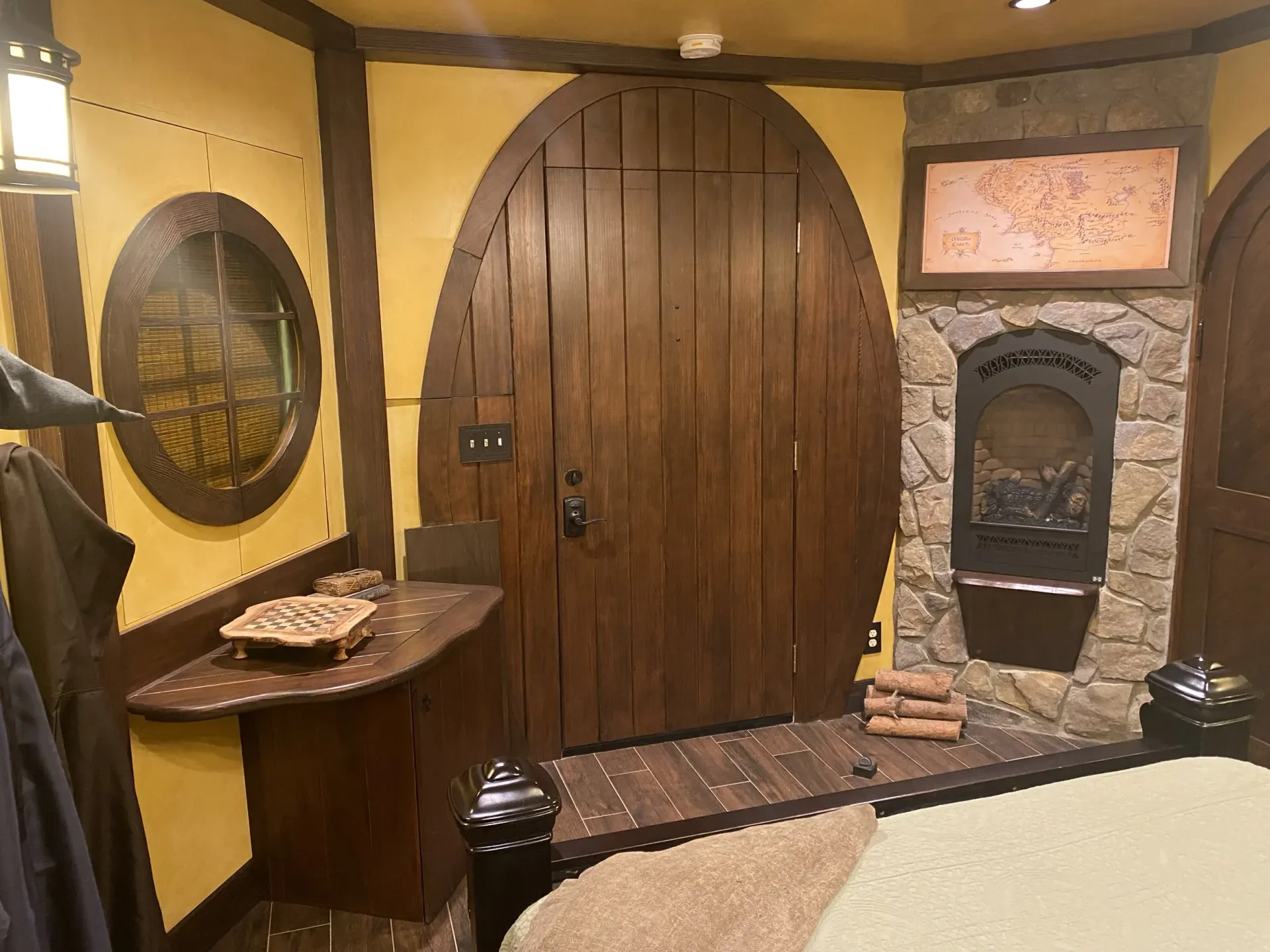 A bedroom with a wooden door and a fireplace.