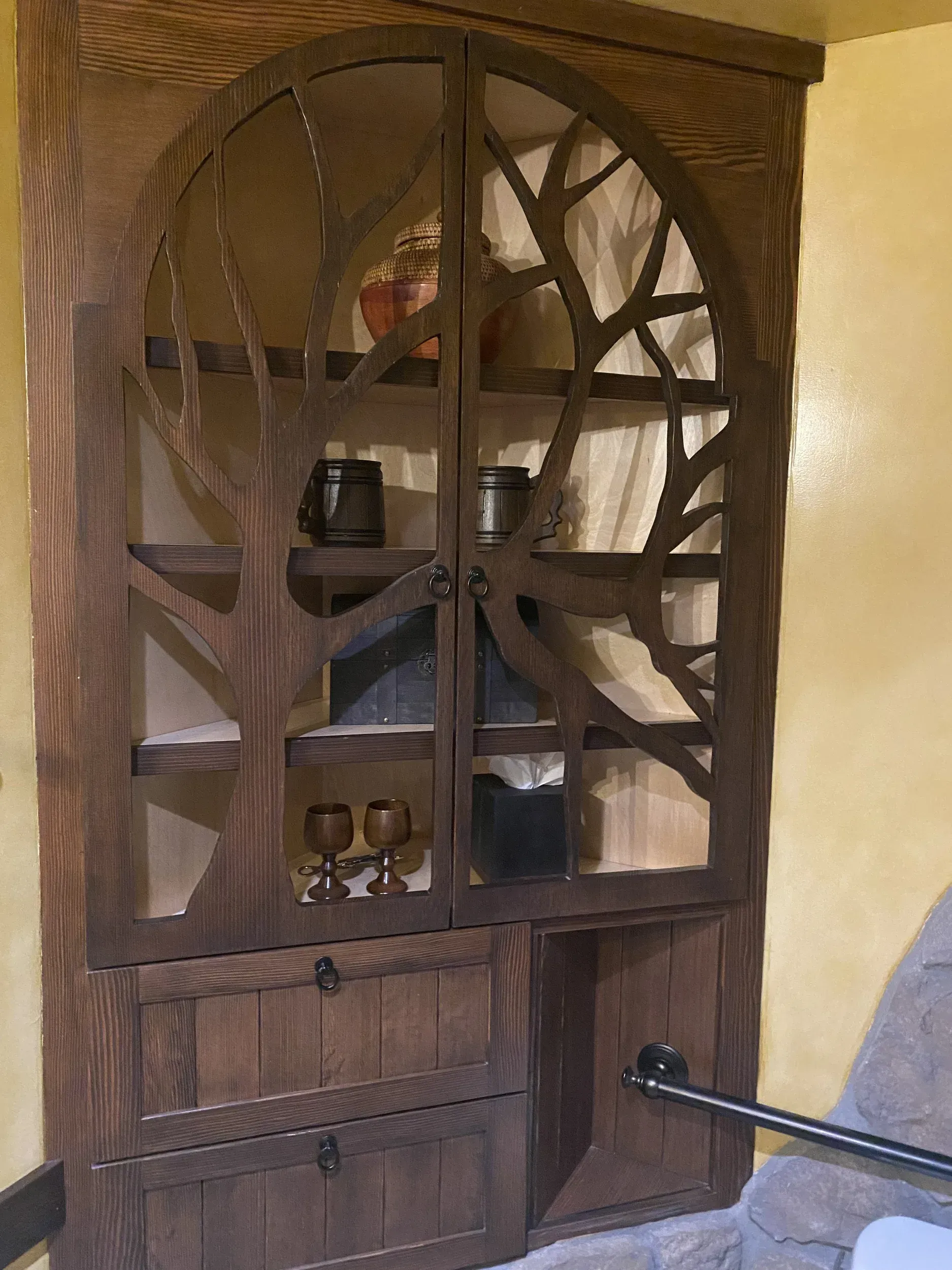 A wooden shelf with a tree design on it