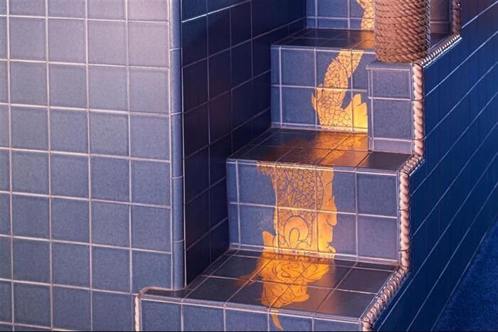 A set of tiled stairs leading up to a blue wall