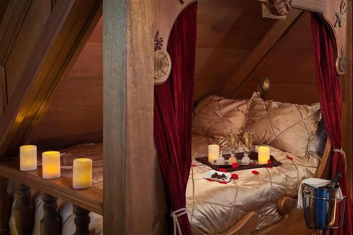 A bed with candles and wine glasses on it