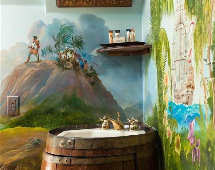 A bathroom with a barrel sink and a painting on the wall.