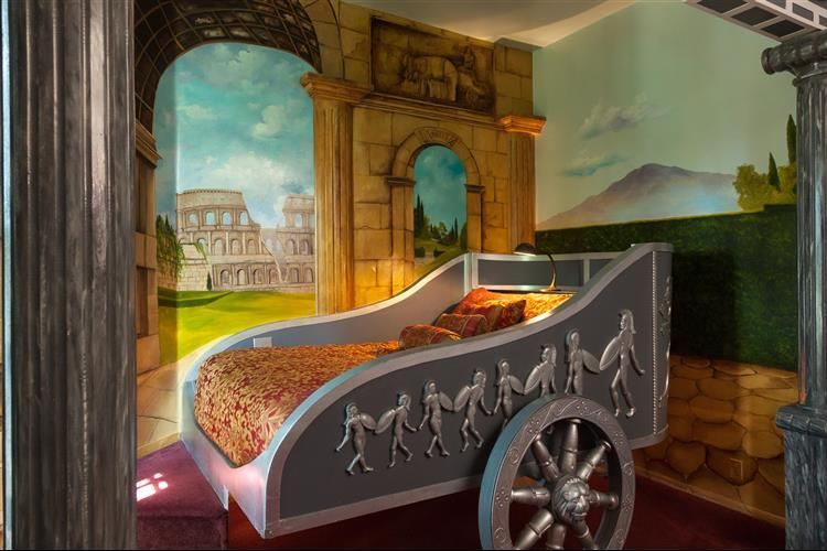 A bedroom with a bed in the shape of a chariot