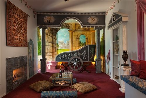 A living room with a fireplace and a painting on the wall.