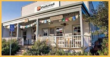 A building with a porch and a sign that says flatbread