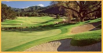 A picture of a golf course with mountains in the background.