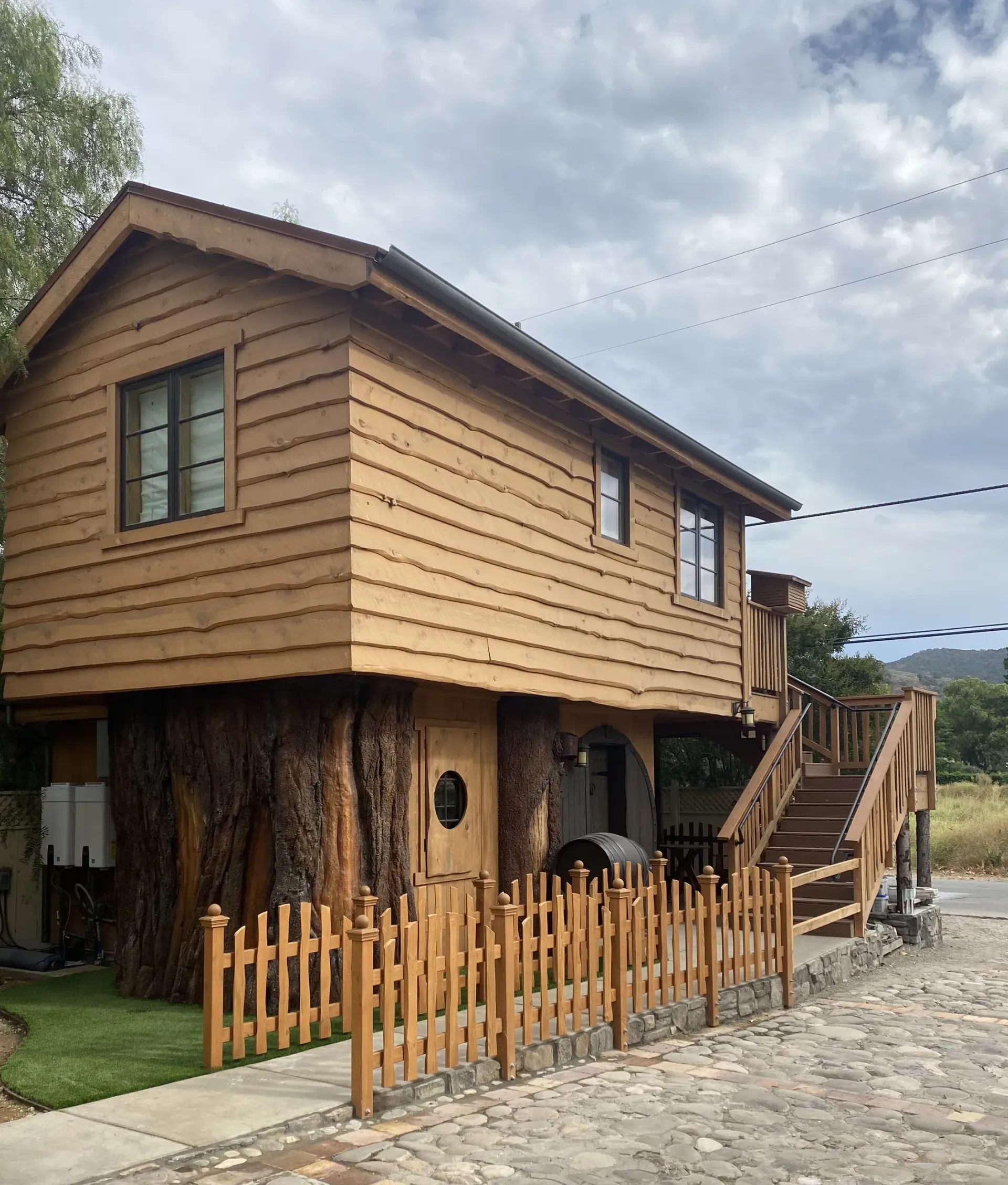 A small wooden house with a fence around it