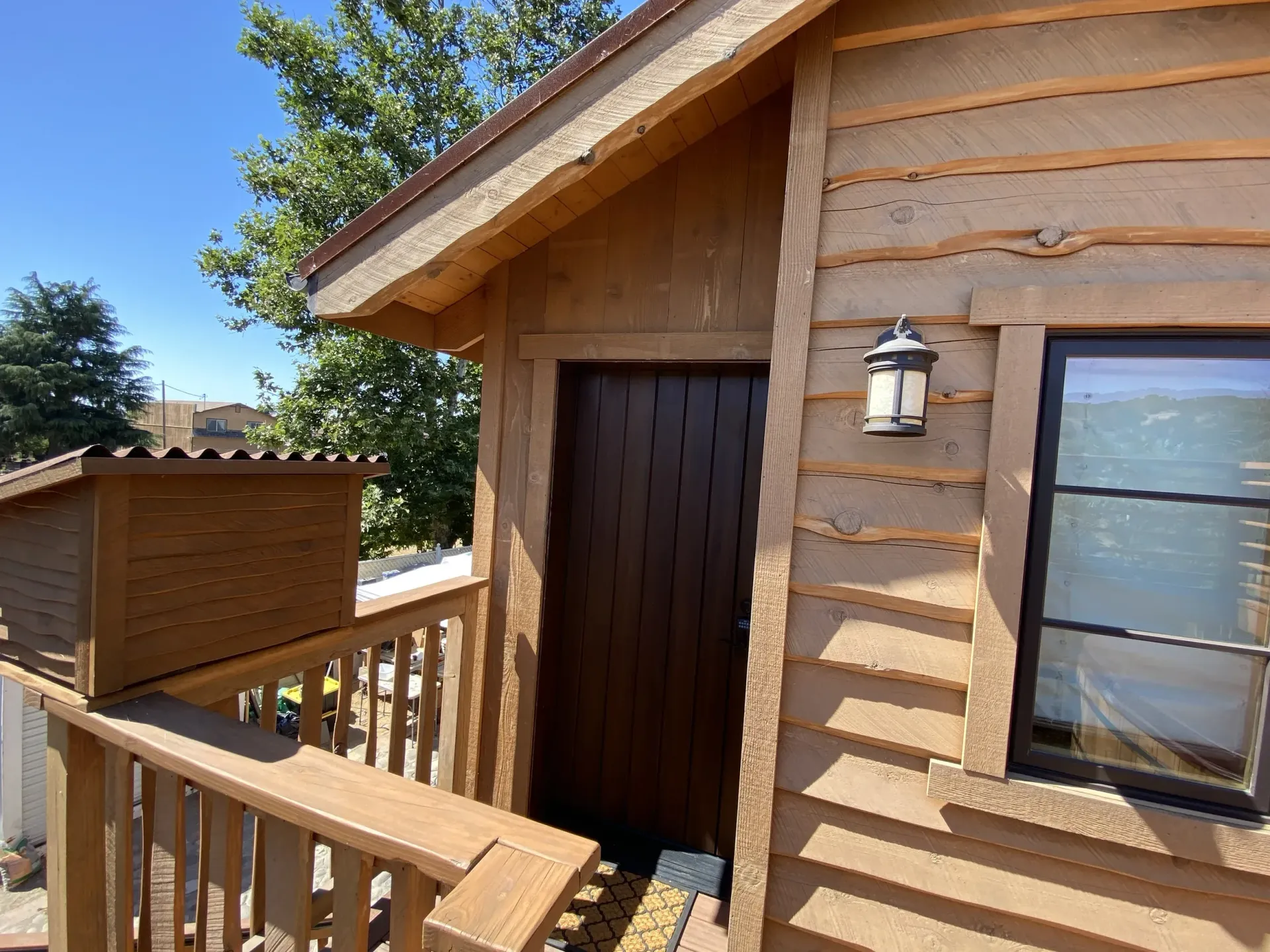 A wooden house with a lantern on the side of it.