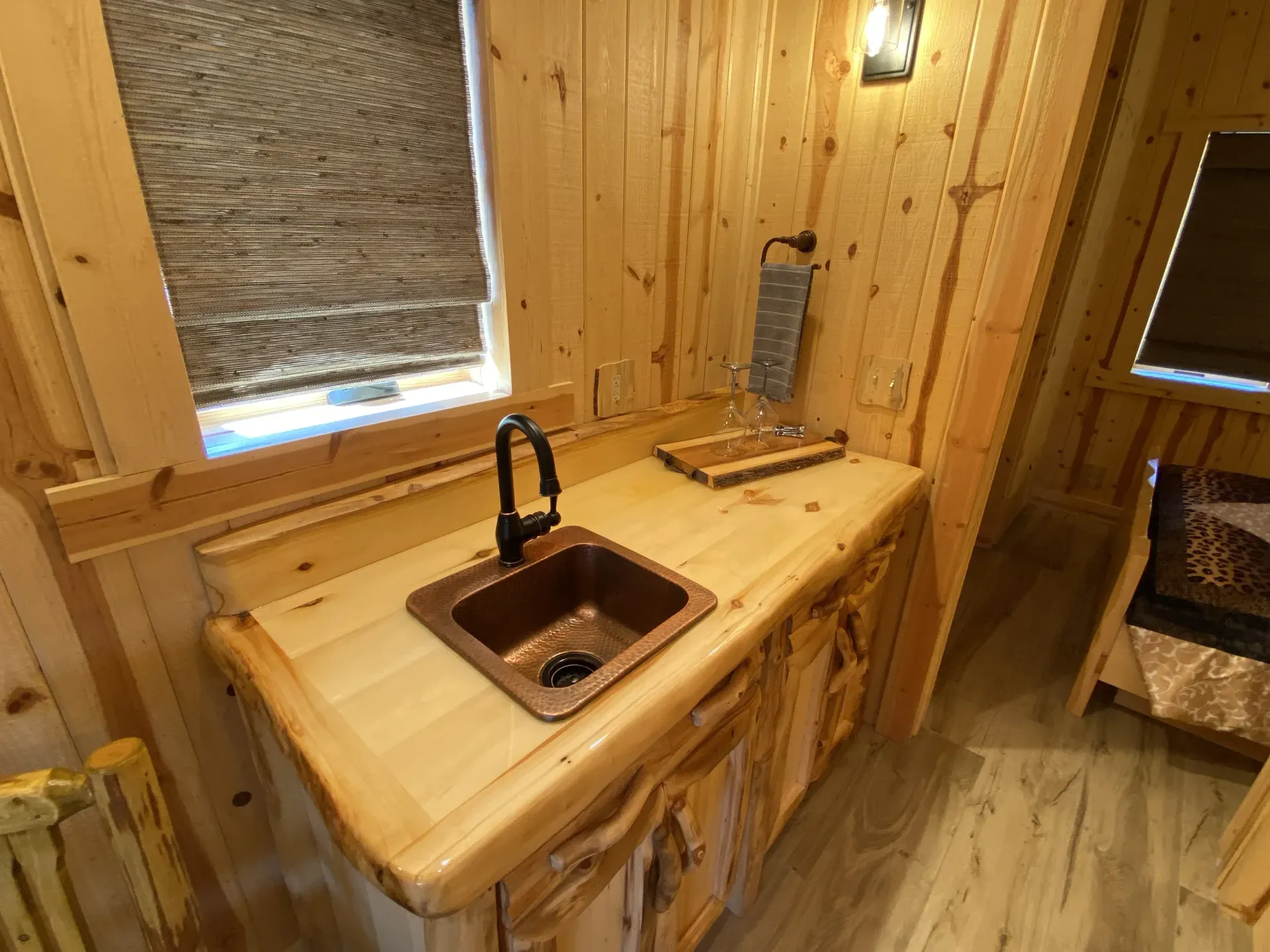 A wooden counter top with a sink and a window.