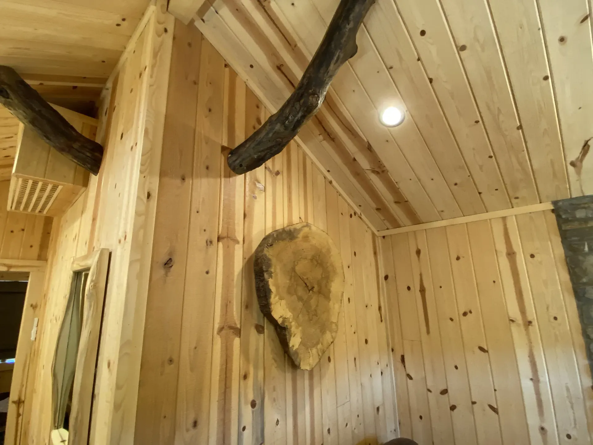 A wooden wall with a piece of wood hanging on it