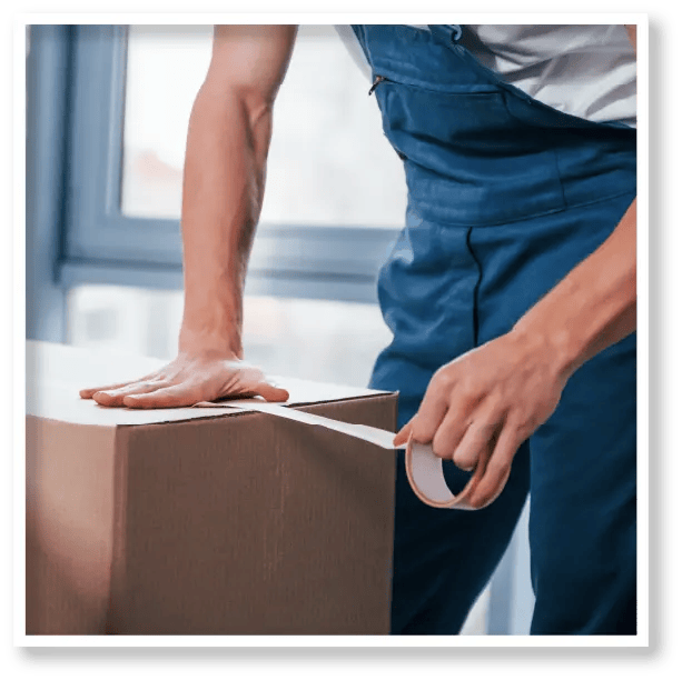 A man is wrapping a cardboard box with tape.