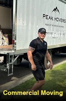 A man is standing in front of a commercial moving truck.