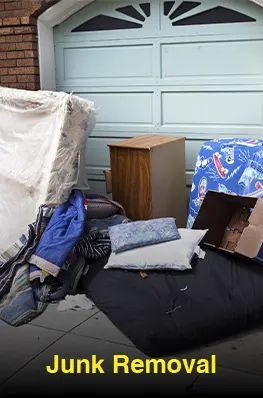 A bunch of junk is sitting on the sidewalk in front of a garage door.