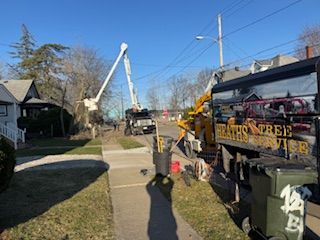 A truck is parked on the side of the road next to a trash can.