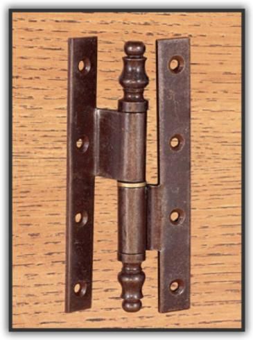 Un primo piano di una cerniera di una porta su una superficie di legno