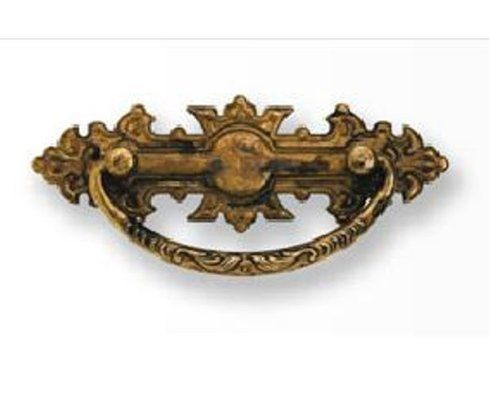 Primo piano di una maniglia di un cassetto in ottone su sfondo bianco.