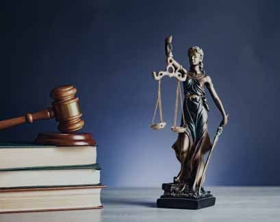 A statue of justice is sitting on a table next to a judge 's gavel.