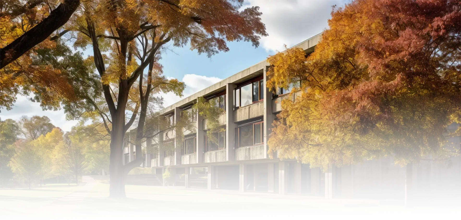 A large building with trees in front of it in autumn