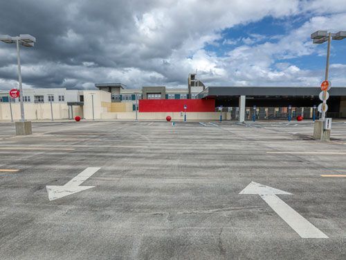 Empty rooftop parking lot with directional arrows, Target store backdrop, overcast sky.