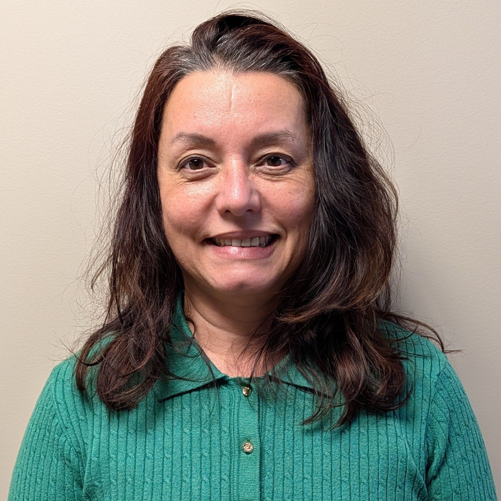 Head-and-shoulders profile photo of Dr. Marta Anghel, MD wearing a green ribbed button-front top, photographed against a plain light-colored background.