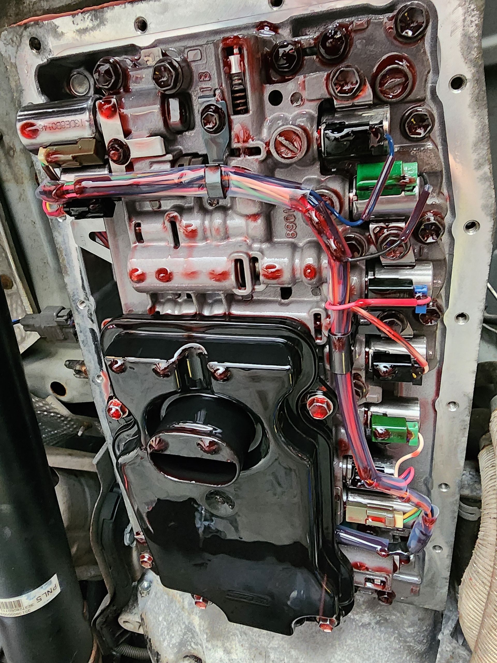 Gears being lubricated with oil from a red can; machinery, close-up.