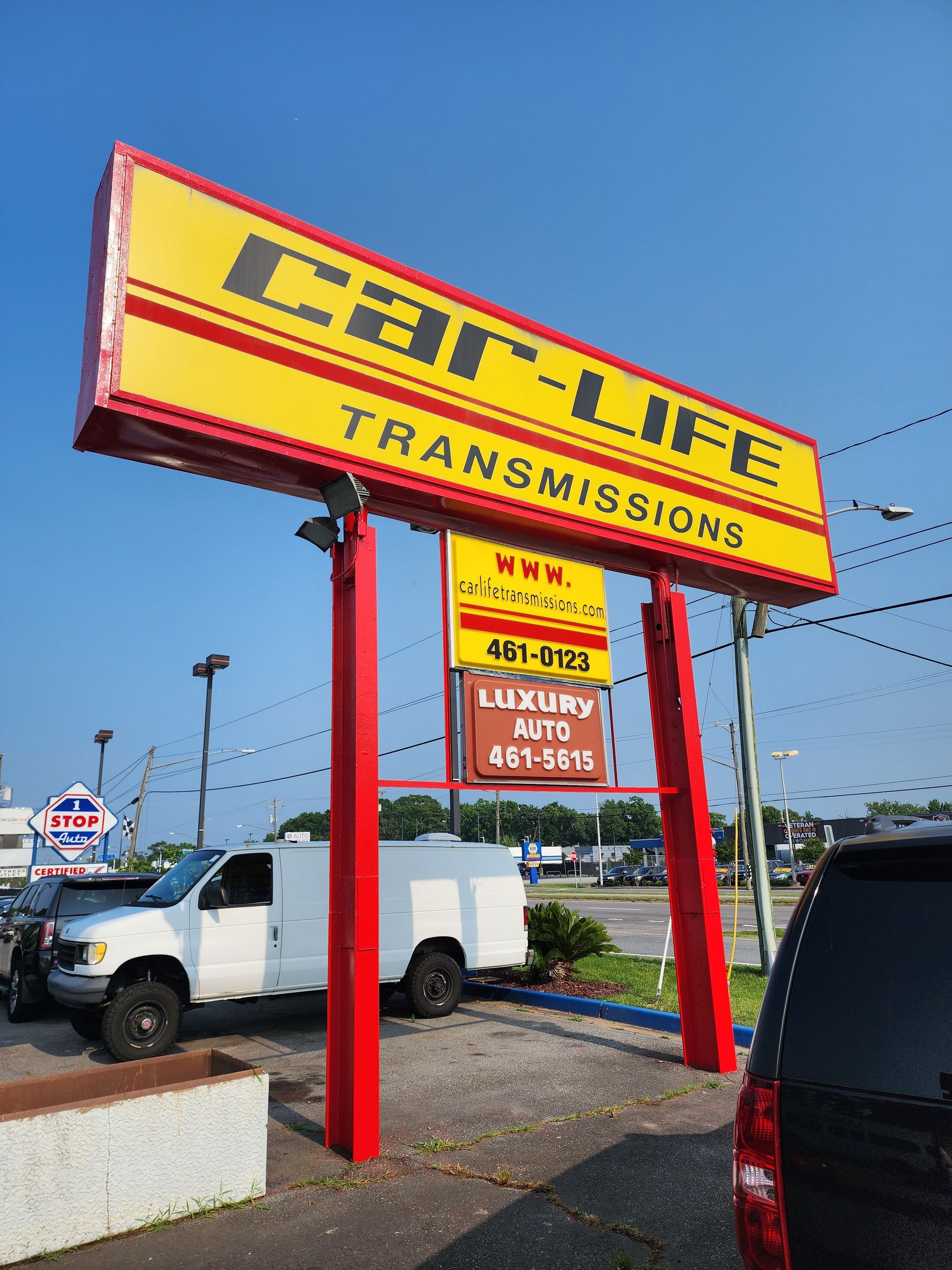 Close-up of a car's gear shift knob, showing gear positions 1-5 and reverse, against a dark background.