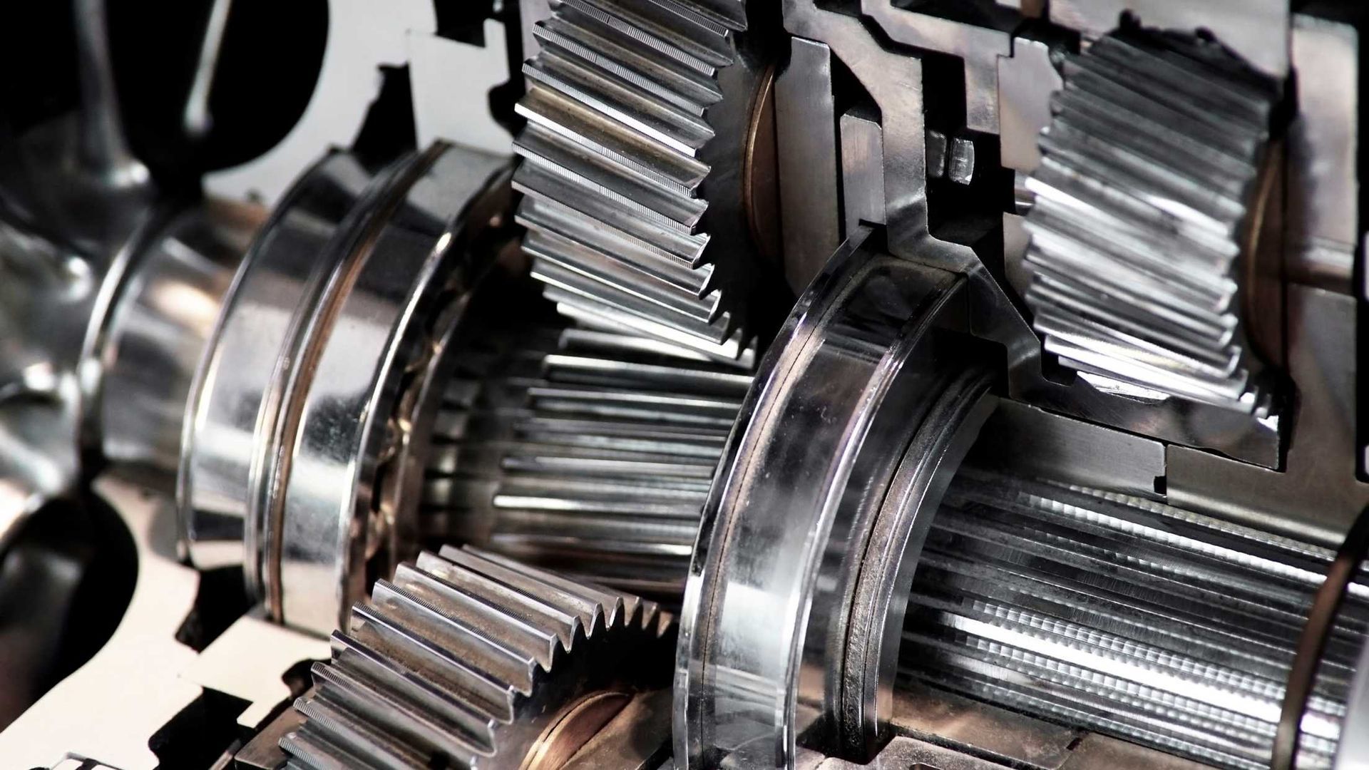 Cutaway view of shiny metal gears and mechanical components in a machine.