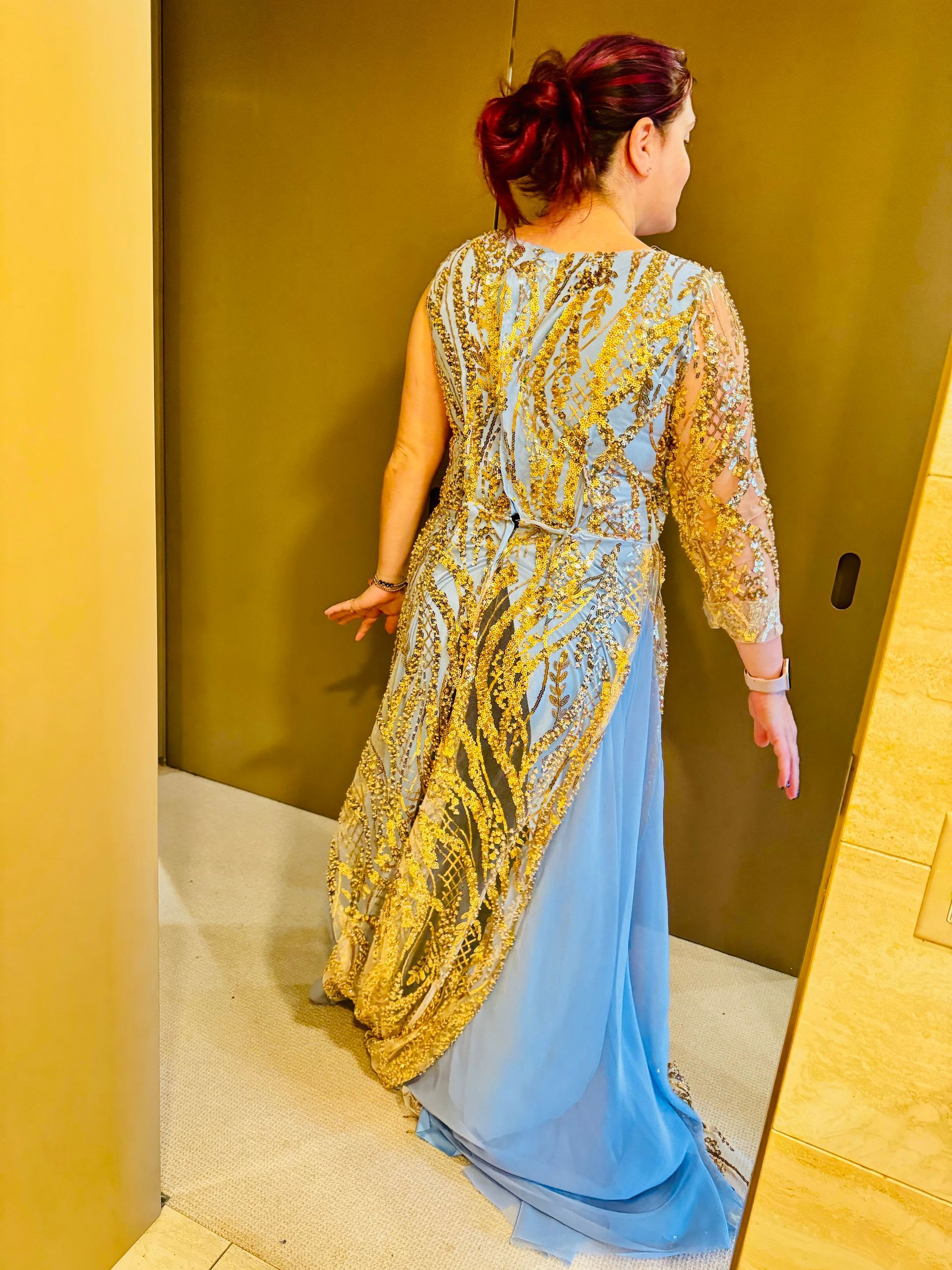 Bridesmaids in blue dresses holding bouquets, outdoor setting.