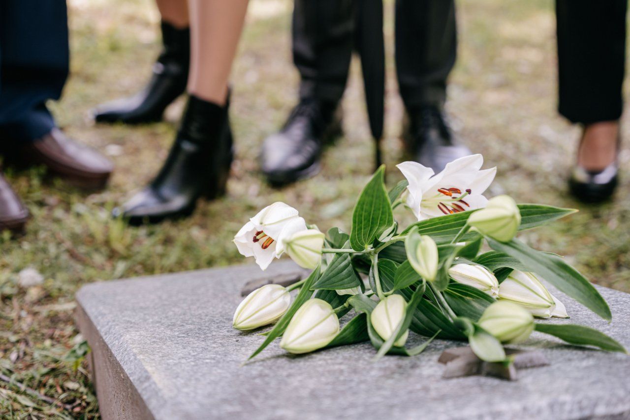 White lilies placed on a gravestone during a memorial service in Philadelphia, PA